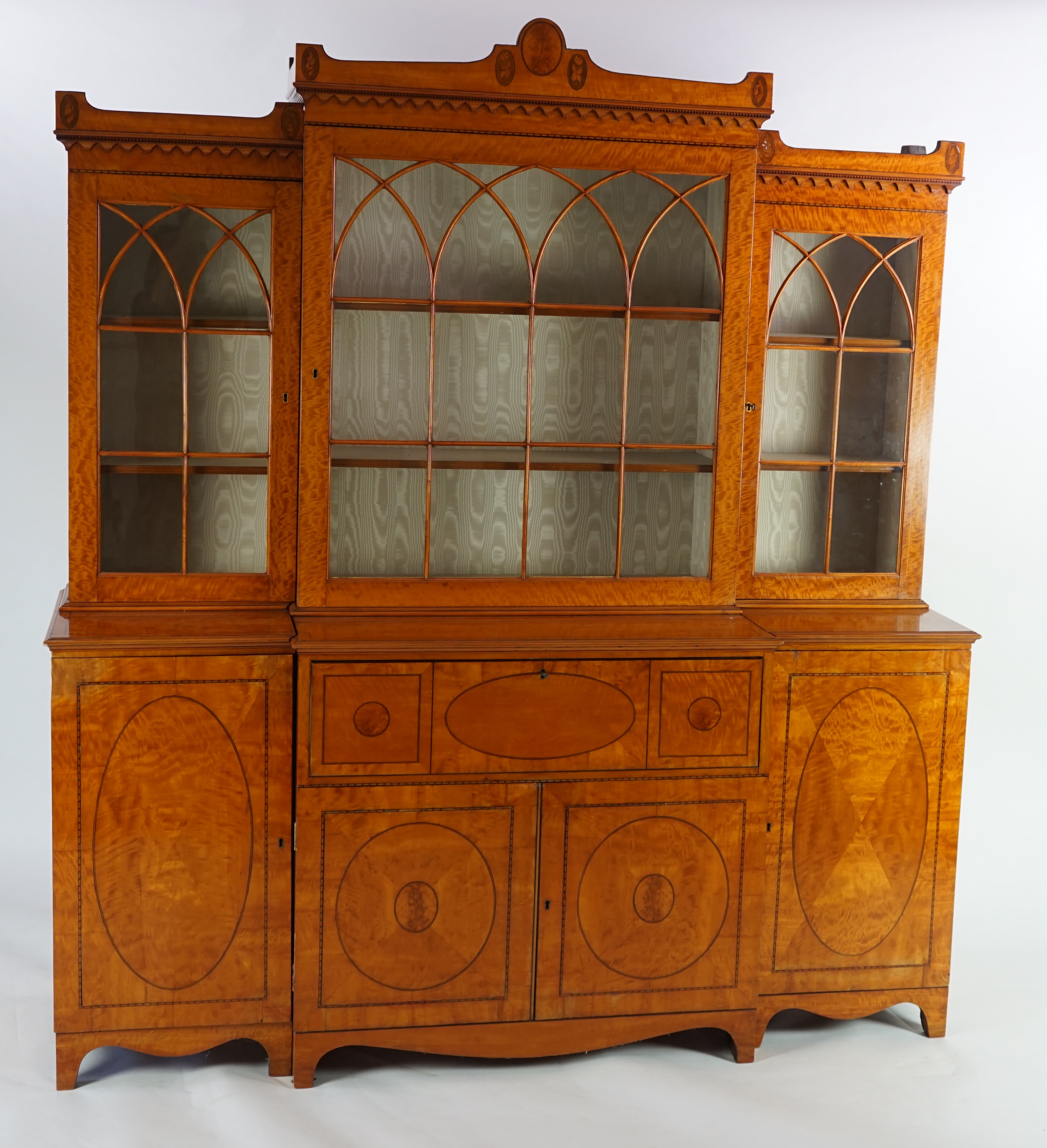 A Sheraton revival ebony strung satinwood breakfront secretaire bookcase